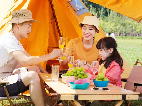 Una familia feliz de tres teniendo un picnic al aire libre —  Fotos de Stock