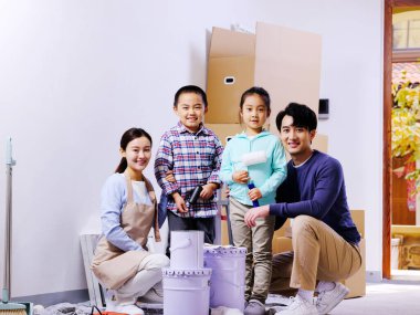 Dört kişilik mutlu bir aile evlerini dekore ediyor.