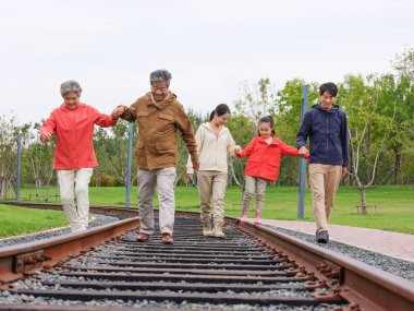 Dışarıda yürüyen beş kişilik mutlu bir aile.