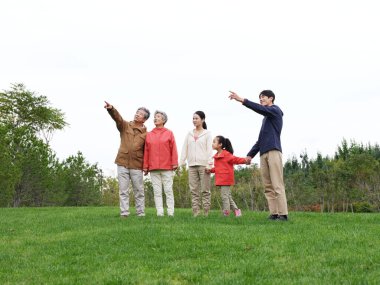 Happy family of five looking at the scenery in the park clipart