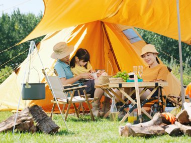 Dışarıda kitap okuyan mutlu bir aile.