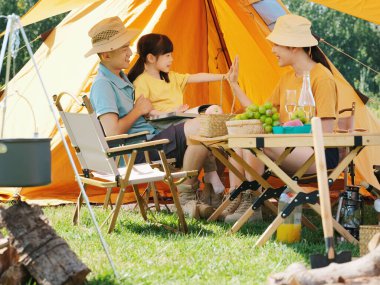 Dışarıda kitap okuyan mutlu bir aile.