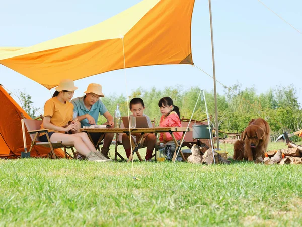 Família feliz de quatro e cão acampar fora — Fotografia de Stock