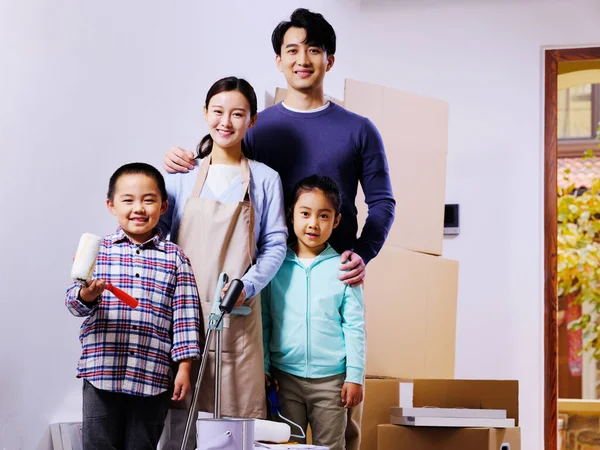 Une famille heureuse de quatre personnes décore leur maison — Photo