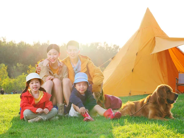Familia feliz de cuatro y perro mascota en la foto al aire libre — Foto de Stock
