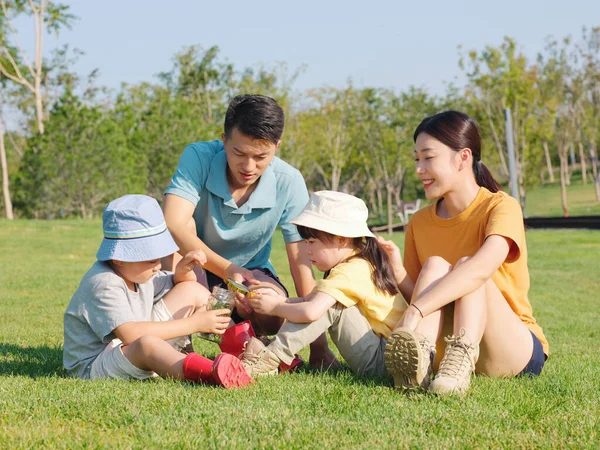 Família feliz de quatro brincando no parque — Fotografia de Stock