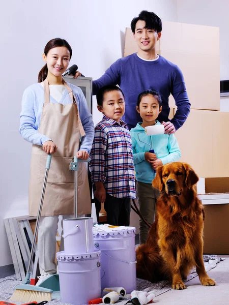 Uma família feliz de quatro e um cão de estimação decorar a casa — Fotografia de Stock