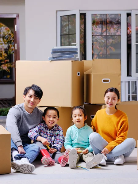 La famille heureuse de quatre personnes s'assit sur le sol pour se reposer — Photo