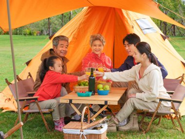 Dışarıda piknik yapan beş kişilik mutlu bir aile.