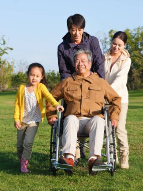 Dört kişilik mutlu bir aile parkta yürüyor.