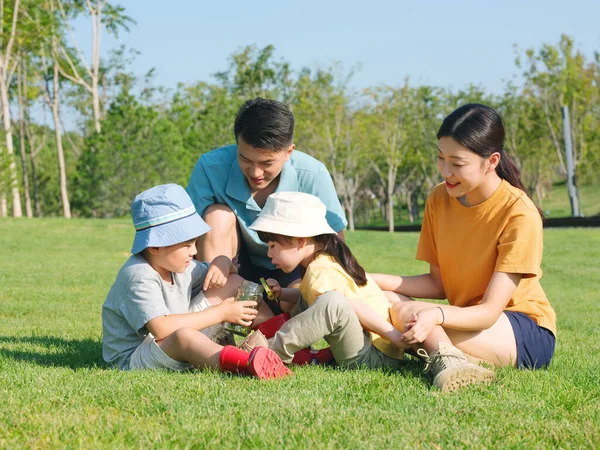 Heureuse famille de quatre personnes jouant dans le parc — Photo