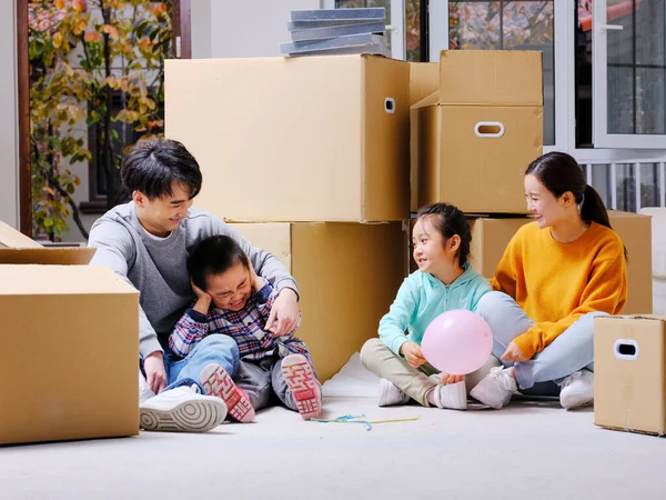 La famille heureuse de quatre personnes s'assit sur le sol pour se reposer — Photo