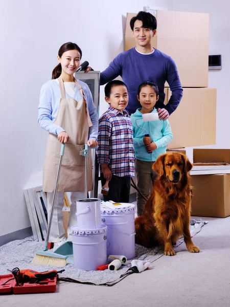 Szczęśliwa czteroosobowa rodzina i pies ozdobić dom — Zdjęcie stockowe