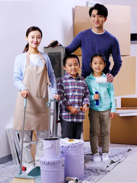 Uma família feliz de quatro decora sua casa — Fotografia de Stock
