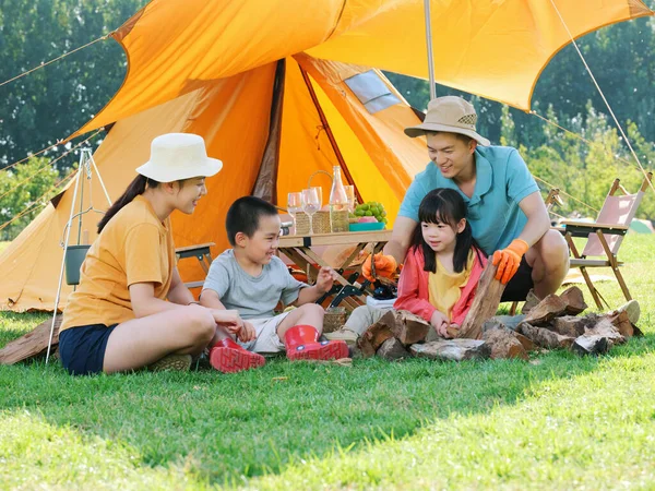 Uma família feliz de quatro acampamentos ao ar livre — Fotografia de Stock