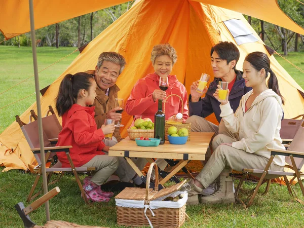 Egy öt tagú boldog család piknikezik a szabadban. — Stock Fotó