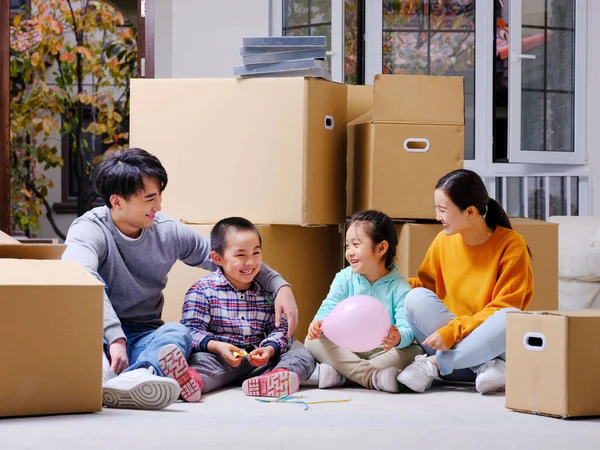 La felice famiglia di quattro persone sedeva a terra per riposare — Foto Stock