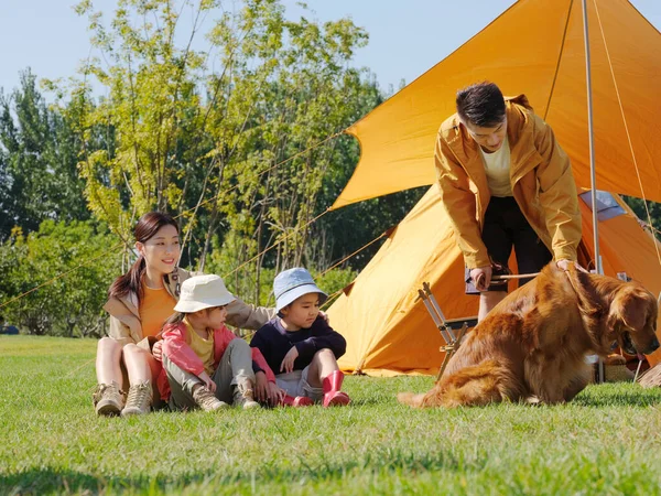 Boldog család négy és kisállat kutya játszik a parkban — Stock Fotó