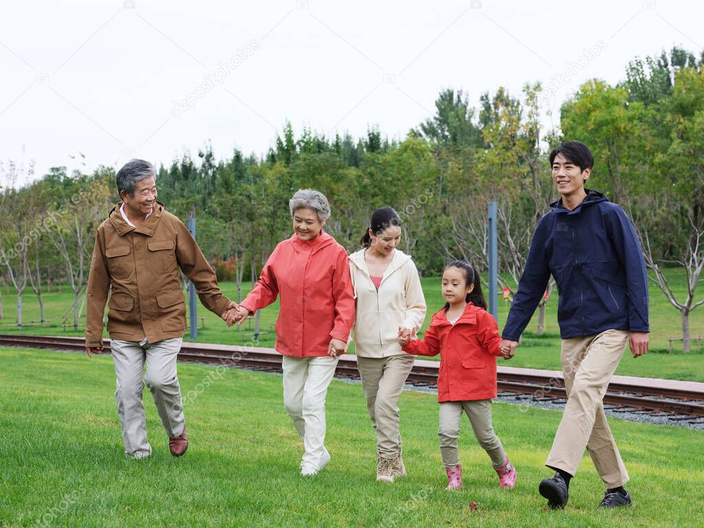 A happy family of five walking outdoors