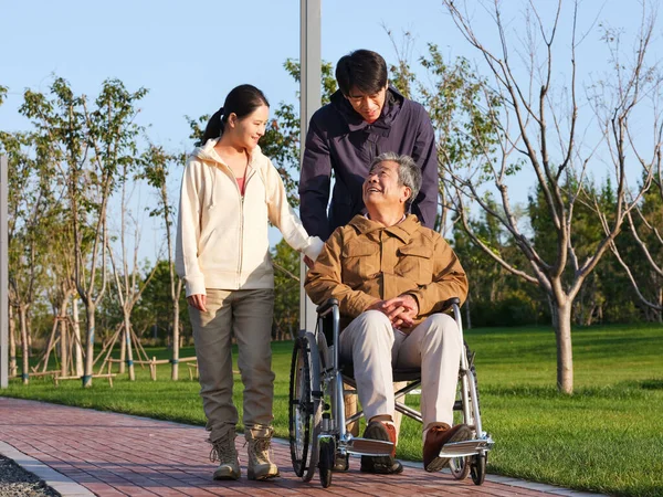 En lycklig familj på tre promenader i parken — Stockfoto