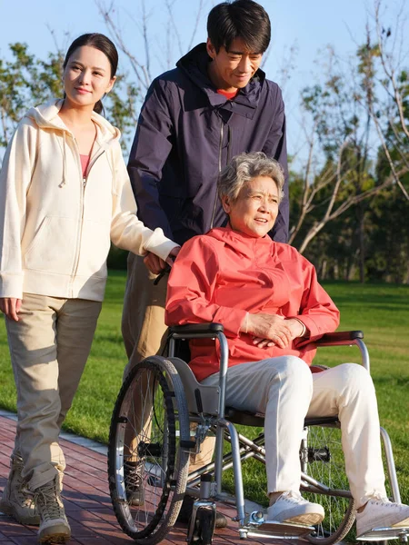 En lycklig familj på tre promenader i parken — Stockfoto