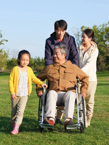 Una famiglia felice di quattro persone che passeggiano nel parco — Foto Stock