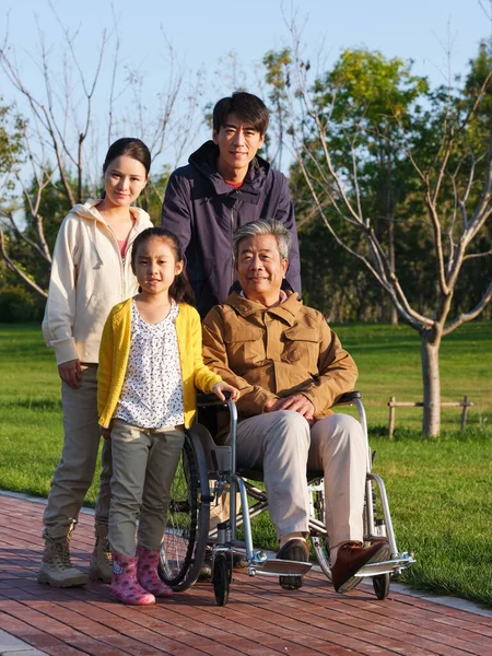 Una famiglia felice di quattro persone che passeggiano nel parco — Foto Stock