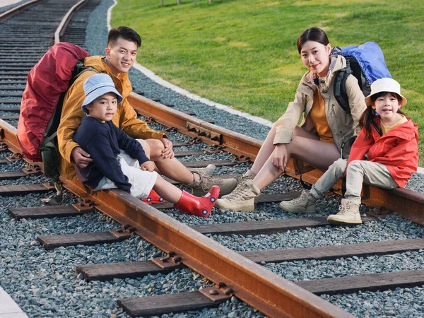 幸福的四口之家坐在轨道上休息 — 图库照片