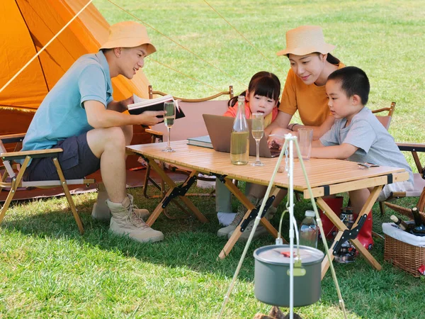 Uma família feliz de quatro acampamentos ao ar livre Imagens Royalty-Free