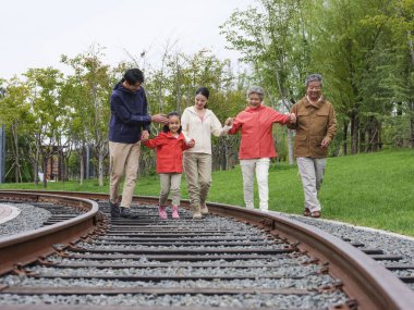 Dışarıda yürüyen beş kişilik mutlu bir aile.