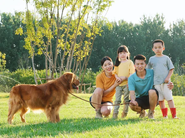 Joyeux famille de quatre et chien de compagnie dans le parc — Photo