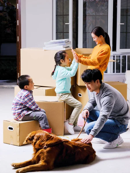 Uma família feliz de quatro e seu cão de estimação estão brincando na sala — Fotografia de Stock