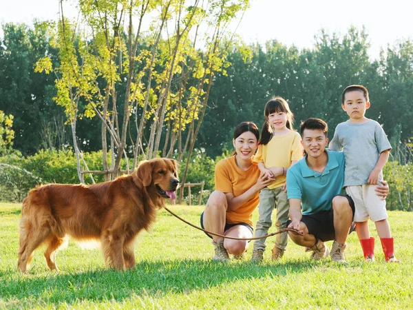 Joyeux famille de quatre et chien de compagnie dans le parc — Photo