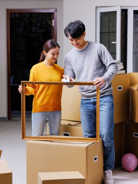 Mutlu genç bir çift yeni bir ev dekore ediyor.