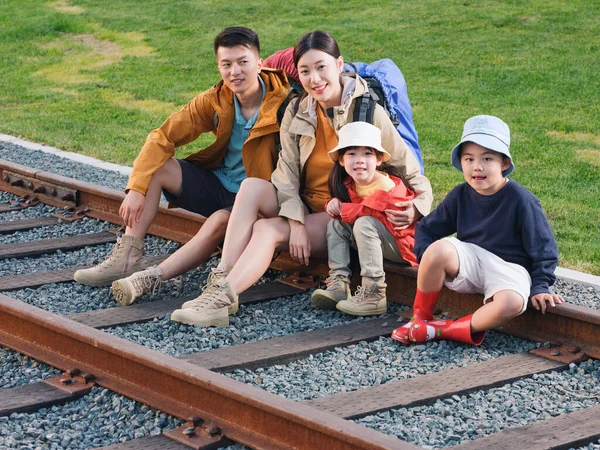 幸福的四口之家坐在轨道上休息 — 图库照片