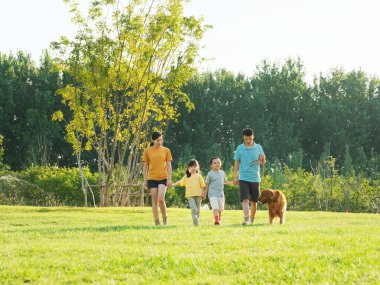 Parkta dört köpekli mutlu bir aile.