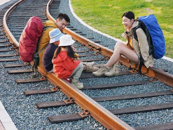 Happy family of four sitting on the track to rest — Stock Photo, Image