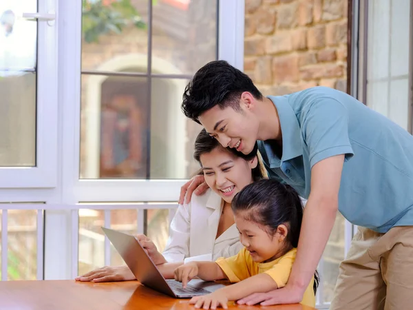 Eine glückliche dreiköpfige Familie mit Laptop — Stockfoto