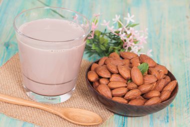 Badem ahşap arka plan ve çikolatalı süt kase