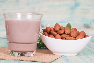 Badem ahşap arka plan ve çikolatalı süt kase