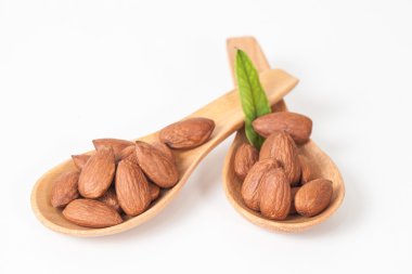 beyaz zemin üzerine tahta kaşık badem