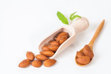 beyaz zemin üzerine tahta kaşık badem