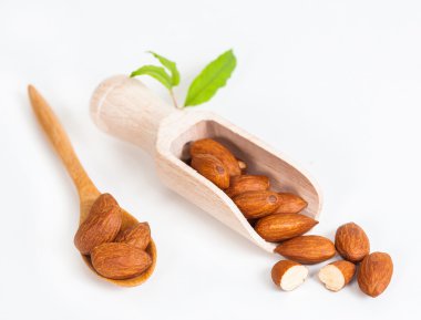 beyaz zemin üzerine tahta kaşık badem