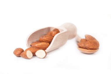 beyaz zemin üzerine tahta kaşık badem