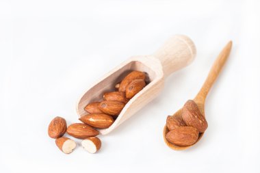 beyaz zemin üzerine tahta kaşık badem