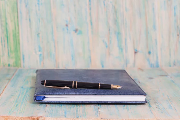 木材の背景の上にペンで日記 — ストック写真