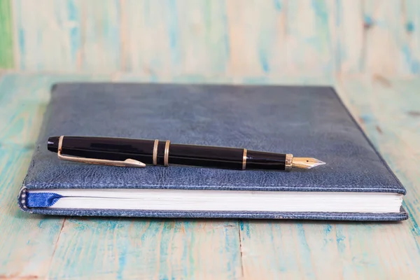 Tagebuch mit Stift auf Holz-Hintergrund — Stockfoto