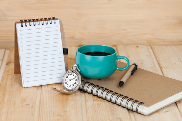 pocket watch and coffee cup on book