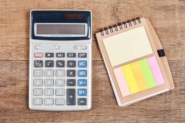 Notebook met lege pagina en Rekenmachine op houten bureau — Stockfoto