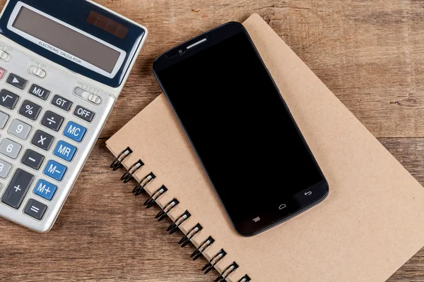 Mobiele telefoon en boek opmerking in vintage houten bureau — Stockfoto